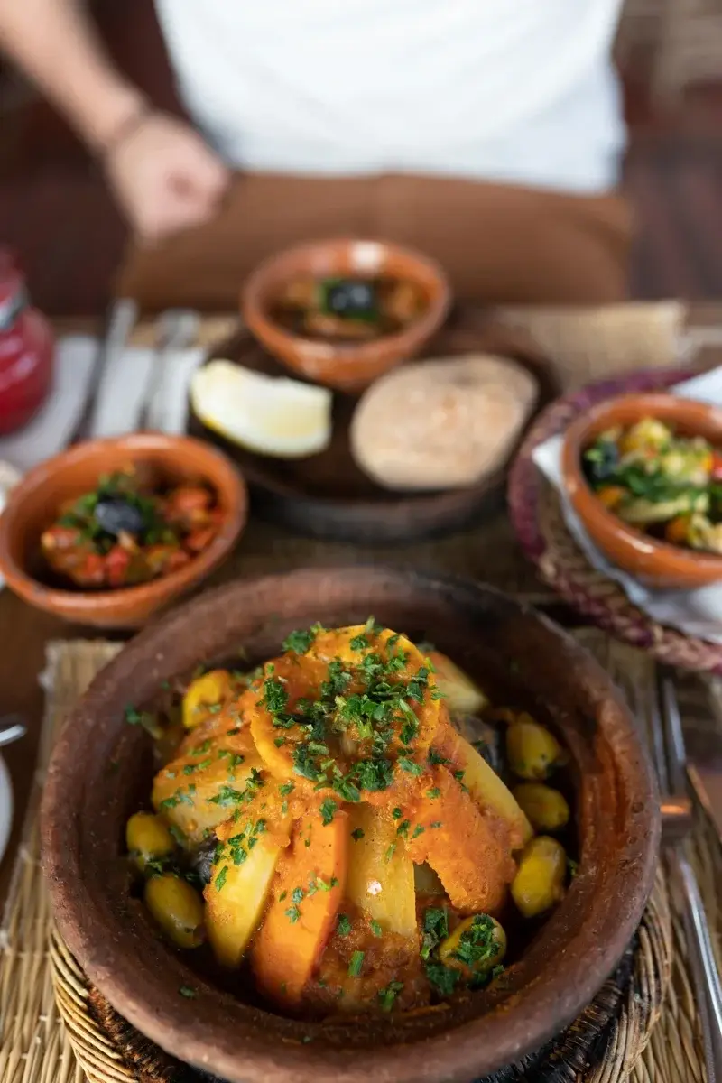 Tajine marroquí de verduras servido en un recipiente de barro