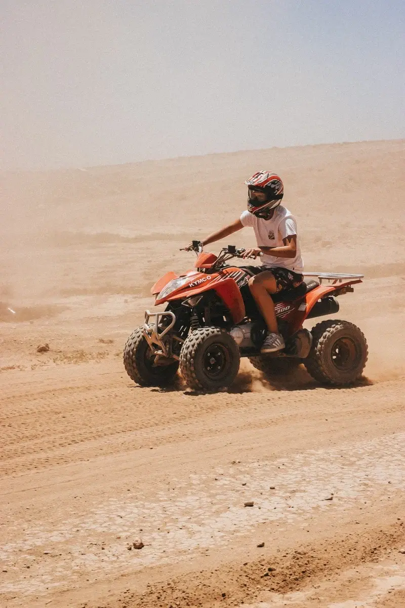 Conductor de quad con casco en una pista polvorienta cerca de Marrakech
