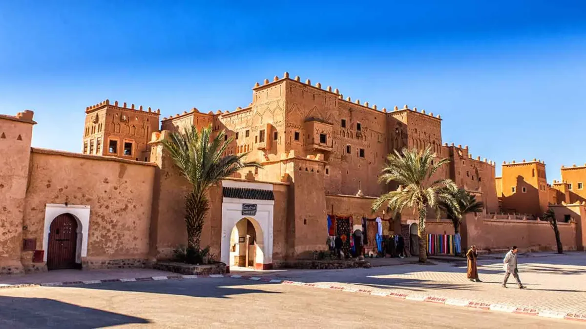 Taourirt Kasbah and palm trees beneath a clear sky in Ouarzazate